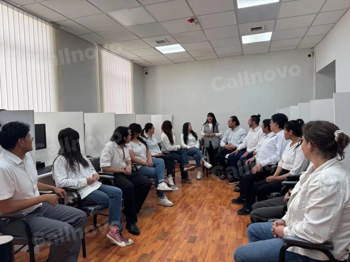 A Callnovo support team in a pre-launch product training session, seated in a circle reviewing the noise-canceling headphone SOPs and common failure points before going live on the account