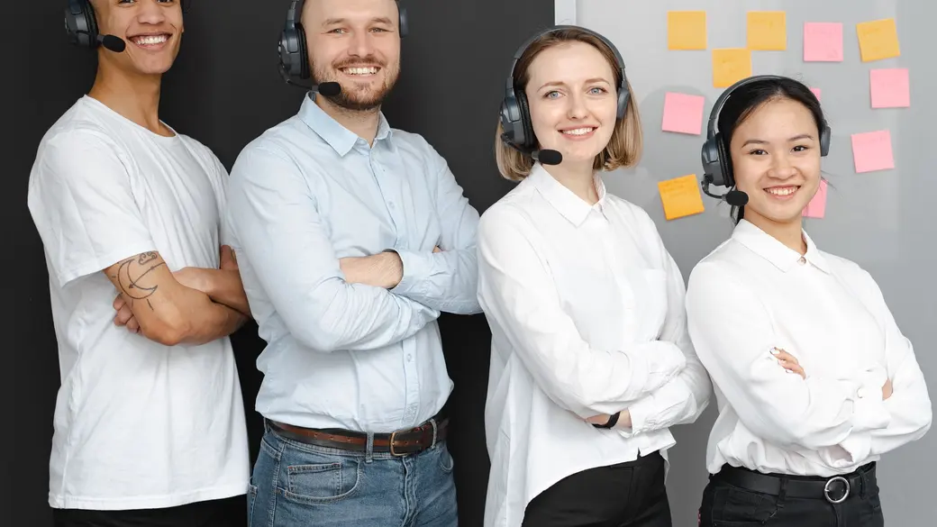Call center agents in headsets working side by side on a large operations floor, the staffing model enterprise BPOs are built around