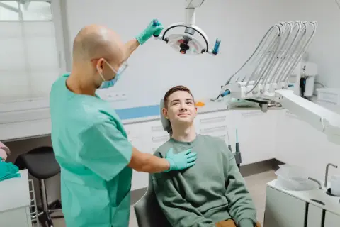 A dentist examining a patient under the dental light